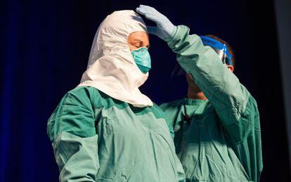 Un enfermero revisa la colocación del traje durante la demostración del CDC en Nueva York.