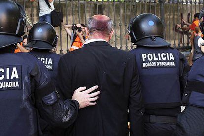 El diputado de ICV Joan Boada, con la cabeza manchada de pintura, entra en la Ciutadella escoltado por los Mossos d&#39;Esquadra.