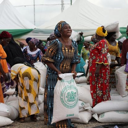 Mujeres recogen sacos de comida en Abuja.