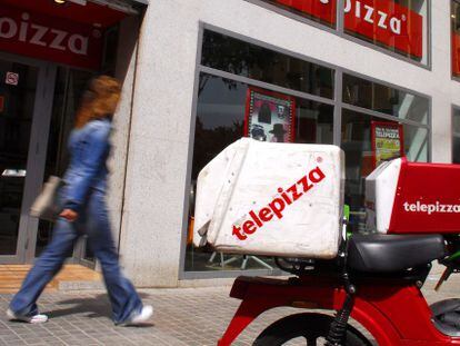 Una moto enfrente de un establecimiento de Telepizza.