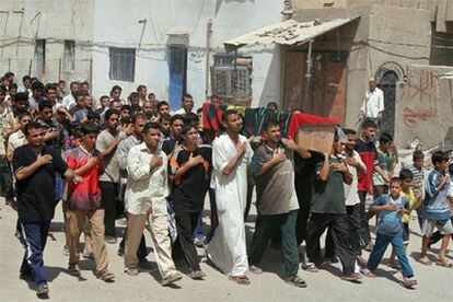 Familiares y amigos portan el féretro de uno de los peregrinos muertos ayer en la estampida de Bagdad.