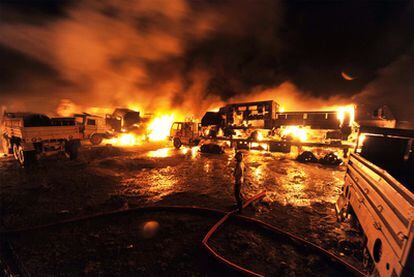 Un bombero trata de extinguir las llamas de varios vehículos atacados por un grupo de supuestos talibanes. Hasta 50 camiones, que se dirigían hacia Afganistán para abastecer a fuerzas de la OTAN, fueron incendiados en el ataque, que se produjo anoche en una localidad próxima a la capital paquistaní, Islamabad, y causó al menos siete muertos.