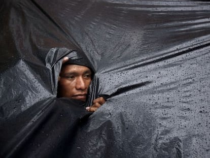 Un ind&iacute;gena Mby&aacute; Guaran&iacute; se protege de la lluvia.