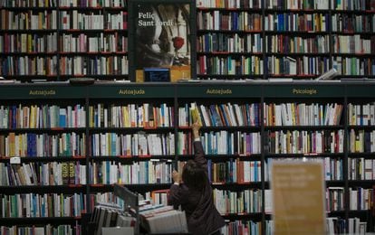 Un cliente coge un ejemplar en una librería barcelonesa dos días de la jornada de Sant Jordi.