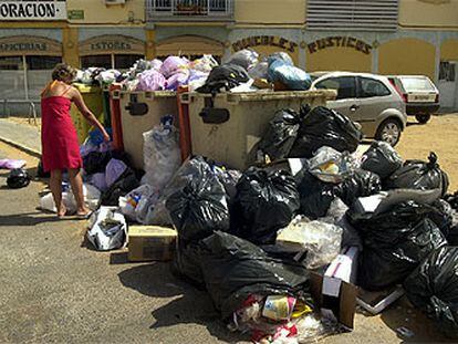 Una vecina, ayer, arroja su basura en Chiclana de la Frontera.