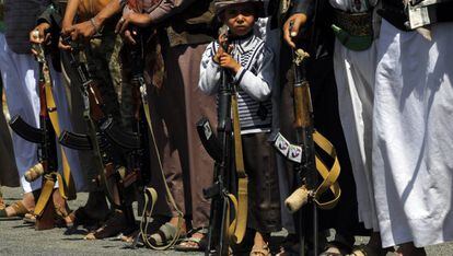 Un ni&ntilde;o sostiene un fusil junto a un grupo de rebeldes Huthi, durante un acto de reclutamiento en San&aacute;.