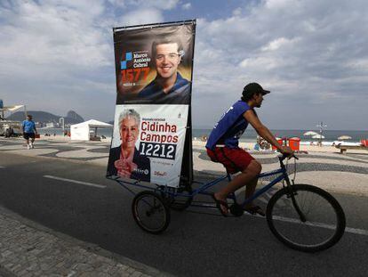 Un hombre por el barrio de Copacabana con propaganda electoral.