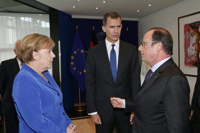 El Rey Felipe VI durante el encuentro que ha mantenido con el presidente francés, François Hollande (d), y la canciller alemana, Angela Merkel (i).