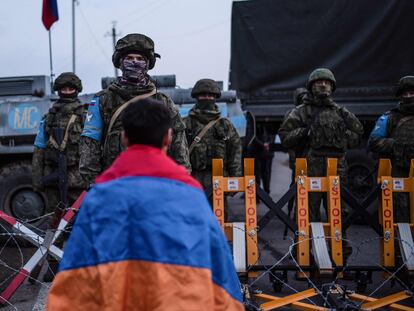 Un manifestante con una bandera armenia frente a tropas rusas en 2022.
