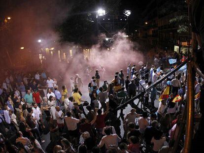 Alborotadores disfrazados de presos lanzan botes de humo en la calle Génova de Madrid mientras habla Mariano Rajoy.
