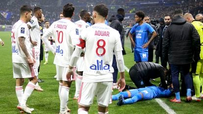 El capitán marsellés Dimitri Payet, en el suelo, tras recibir un botellazo en la cabeza al inicio del Lyon-Olympique de Marsella, este domingo.