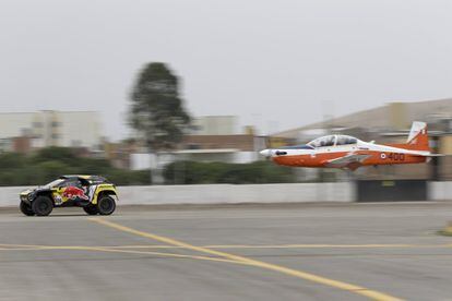 Los pilotos Sebastien Loeb (Francia) y Daniel Elena (Mónaco) compiten contra un avión en una carrera de exhibición, en la inauguración del Dakar 2019, en Lima (Perú), el 6 de enero de 2019.