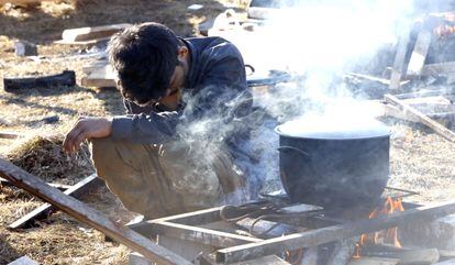Un chico cocina comida en el campamento de Lipa el 18 de febrero de 2021.