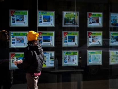 Una mujer mira la oferta de viviendas en una inmobiliaria, el martes 27 de febrero.
