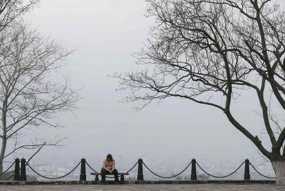 Un hombre descansa en un banco en un frío día de primavera en el centro de Kiev, Ucrania.