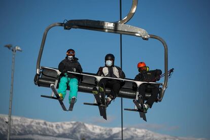 Tres esquiadores con mascarilla, en un telesilla de la Masella.