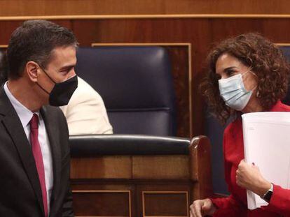 El presidente del Gobierno, Pedro Sánchez, conversa con la ministra de portavoz y de Hacienda, María Jesús Montero (derecha), en el Congreso de los Diputados.