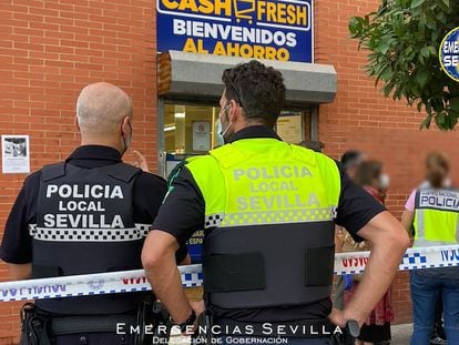 Varios agentes de la policía en las inmediaciones del supermercado de Sevilla en el que ha sido abatido un atracador este viernes por la tarde.