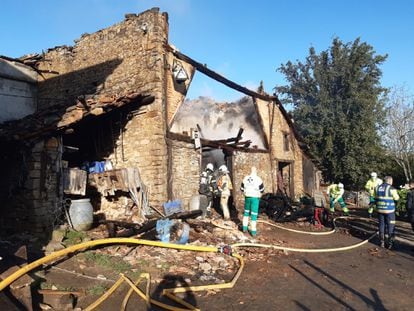 Los bomberos trabajan en la extinción de las llamas en el caserío de Okondo (Álava) en el que se ha producido un incendio en la madrugada de este jueves.
