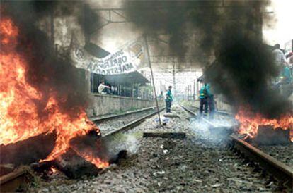 Obreros de una empresa de porteros de inmuebles bloquean con barricadas ardiendo la estación de Avellaneda, en la capital argentina.