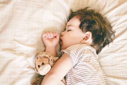 Niño duerme en su cama.