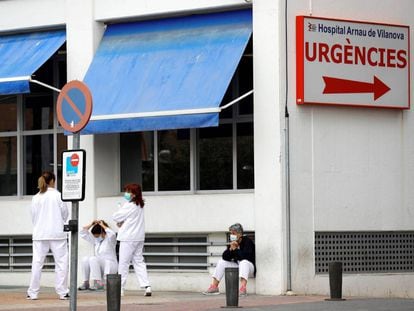Personal sanitario del Hospital Arnau de Vilanova descansa unos minutos ante la puerta de urgencias.