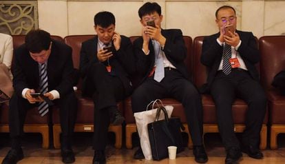 El uso del móvil para pagos en China se ha disparado. En la foto, varias personas consultan sus dispositivos durante el último congreso del Partido Comunista.