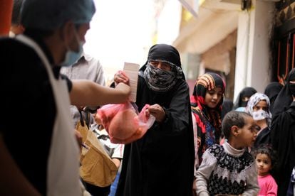 Una mujer recibe una ración de comida este julio en Saná, en Yemen.