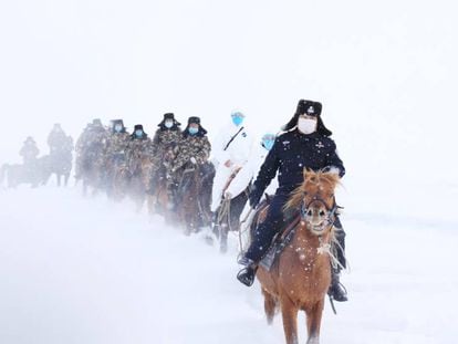 Autoridades fronterizas viajan a caballo para visitar aldeas remotas e informar sobre el coronavirus a sus residentes en Altay (China).