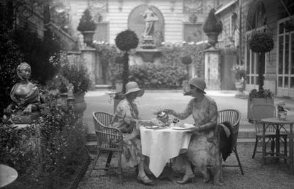 Dos mujeres toman té en el jardín del hotel Ritz de París, en 1930.  