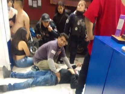 Testigos y policías auxilian a un hombre que fue herido en el ataque armado a una barbería en Salamanca, la noche de este domingo, en una imagen compartida en redes sociales.