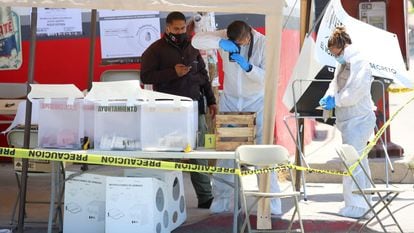 Técnicos forenses trabajan en una casilla electoral donde un hombre arrojó una cabeza humana, en Tijuana, en junio de 2021.
