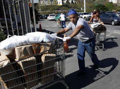 Un hombre compra alimentos en Caracas ante el temor a que se disparen los precios, en un hipermercado abierto ayer.