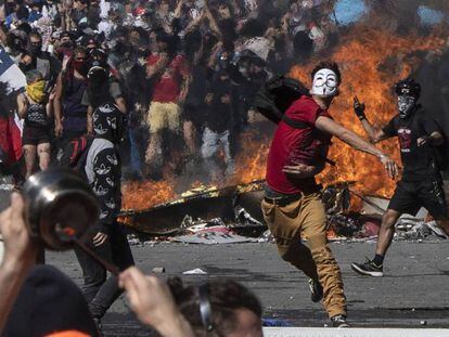 Un joven lanza piedras contra la policía durante una protesta en Santiago de Chile. 
