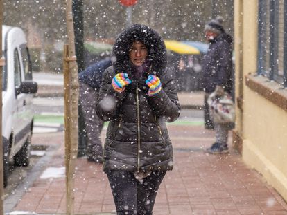 Una mujer se protege de la nieve, este lunes en Teruel, donde la mínima fue de -6°.