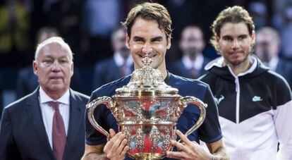 Federer posa con el trofeo, con Nadal en segundo plano.
