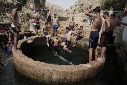 Palestinos e israelíes se bañan en un manantial de Ein Fawwar, cerca de la ciudad Cisjordania de Jericó, con temperaturas en el valle de Jordan que llegaron a 48 grados centígrados.