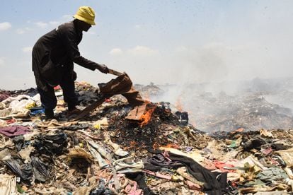 Un hombre quema unos pantalones en el vertedero de Dandora, en Nairobi, el pasado 19 de septiembre.