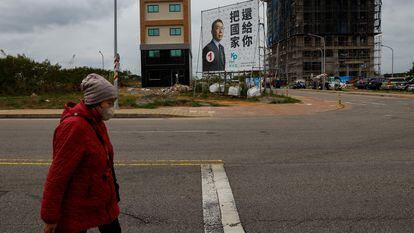 Una mujer camina frente a un cartel electoral del candidato Ko Wen-je, del Partido Popular de Taiwan, en Kinmen a finales de diciembre pasado.
