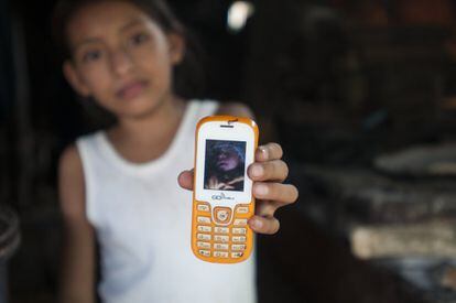 Una niña, tía de Mario Constanza, muestra en un teléfono la foto del bebé,  que nació con microcefalia y posiblemente murió a causa del virus del zika. 