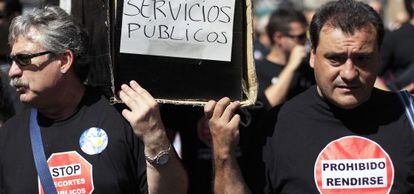Dos funcionarios municipales cargan el féretro de los servicios públicos.