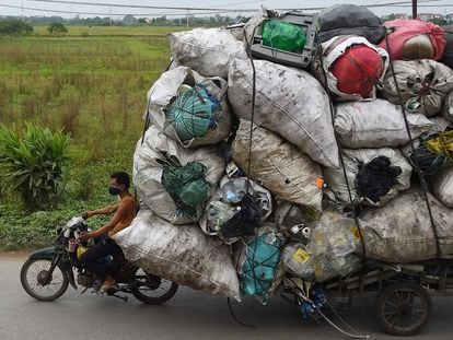 Una persona transporta residuos de plástico para su reciclaje en los suburbios de Hanoi (Vietnam).