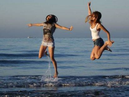 Foto de un lector donde dos hermanas saltan en una playa del Rincón de la Victoria.
