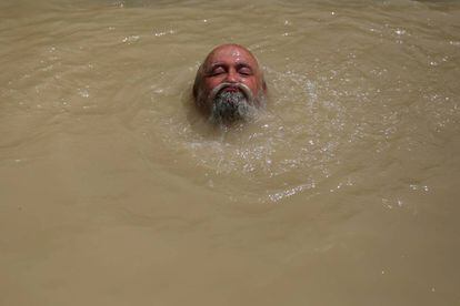 Un peregrino ortodoxo serbio se sumerge en las aguas del río Jordán, cerca de la ciudad cisjordana de Jericó.