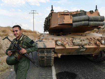 Un soldado turco asegura una carretera antes de que un tanque del Ejército avance hacia la frontera turco-siria, en Ceylanpinar.