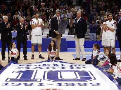 Sergi Llull, Lolo Sainz, Pablo Laso, Felipe Reyes, Rafael Rullán, Sergio Rodríguez, Rudy Fernández y Fernando Romay rodean a Antonio Martín, con la placa conmemorativa en memoria de su hermano Fernando