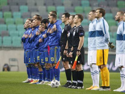 Los jugadores de Kosovo escuchan el himno de su país antes de un partido.