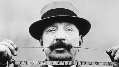 Retrato de un hombre que mide la longitud de su bigote con una cinta métrica en 1905.