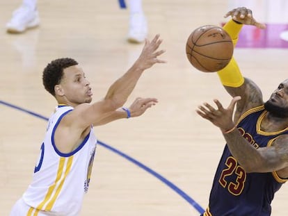 Stephen Curry y LeBron James pugnan por un balón.