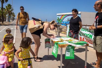 Recogida en una playa de Sanlúcar de firmas a contrarreloj de profesores y padres para que se regule por ley la bajada de la ratio en Andalucía.